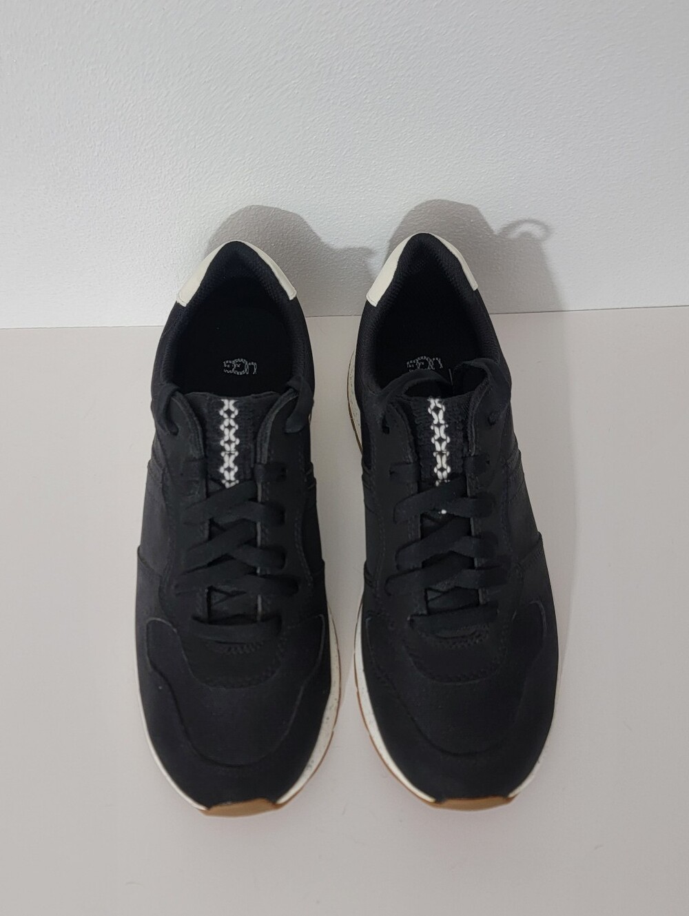 UGG Women's Black And White Retrainer sneakers feature a classic lace-up design